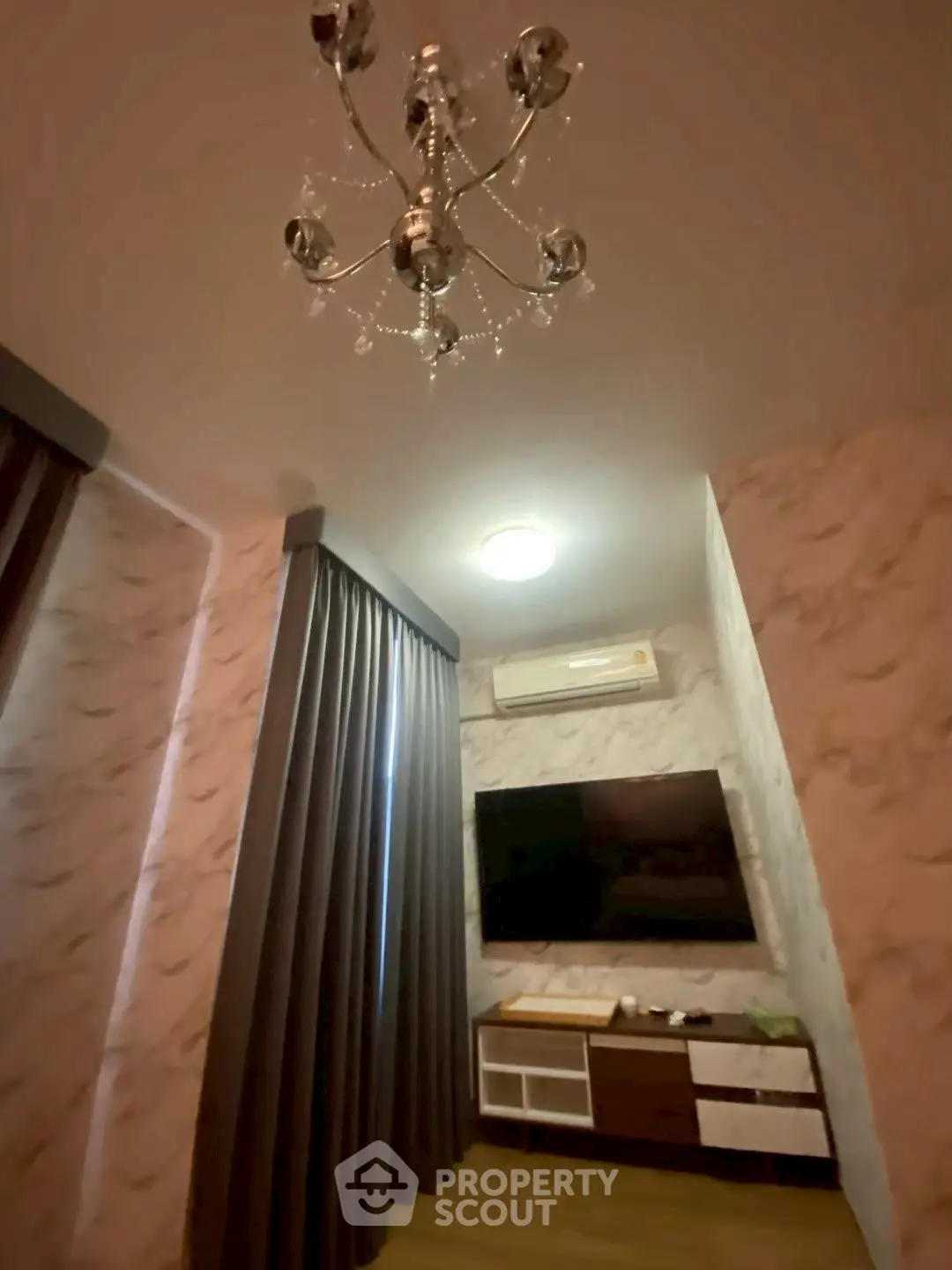 Elegant living room with modern chandelier and wall-mounted TV
