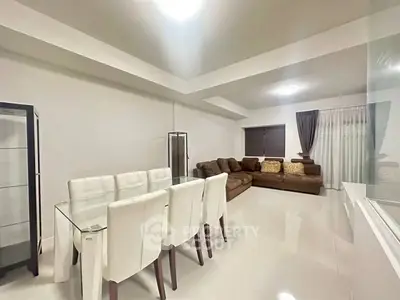 Spacious living room with modern dining area and cozy seating in elegant apartment.
