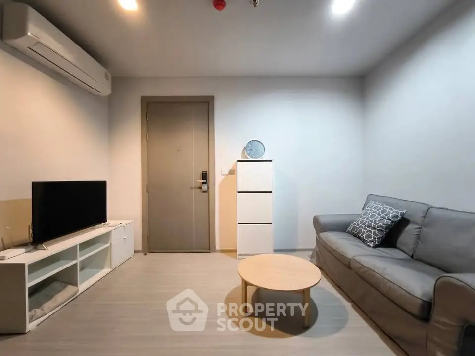Modern living room with sleek furniture and minimalist design, featuring a cozy sofa and stylish decor.
