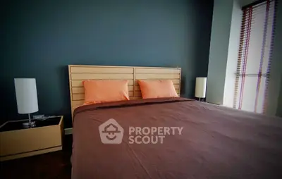 Modern bedroom with stylish decor and natural light, featuring a comfortable bed and elegant lamps.