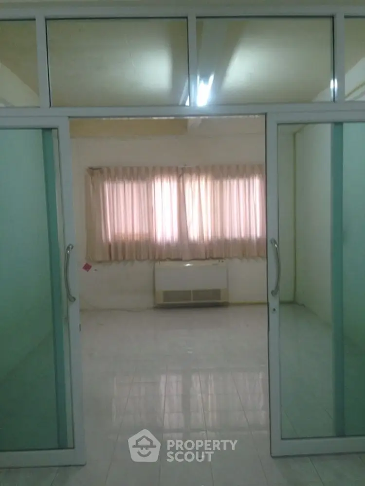 Spacious room with glass doors and large window, ideal for office or study space.