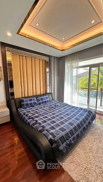 Luxurious bedroom with modern design and large windows offering natural light and garden view.
