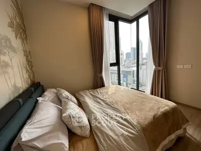 Cozy bedroom with city view, featuring large windows and elegant curtains, perfect for urban living.