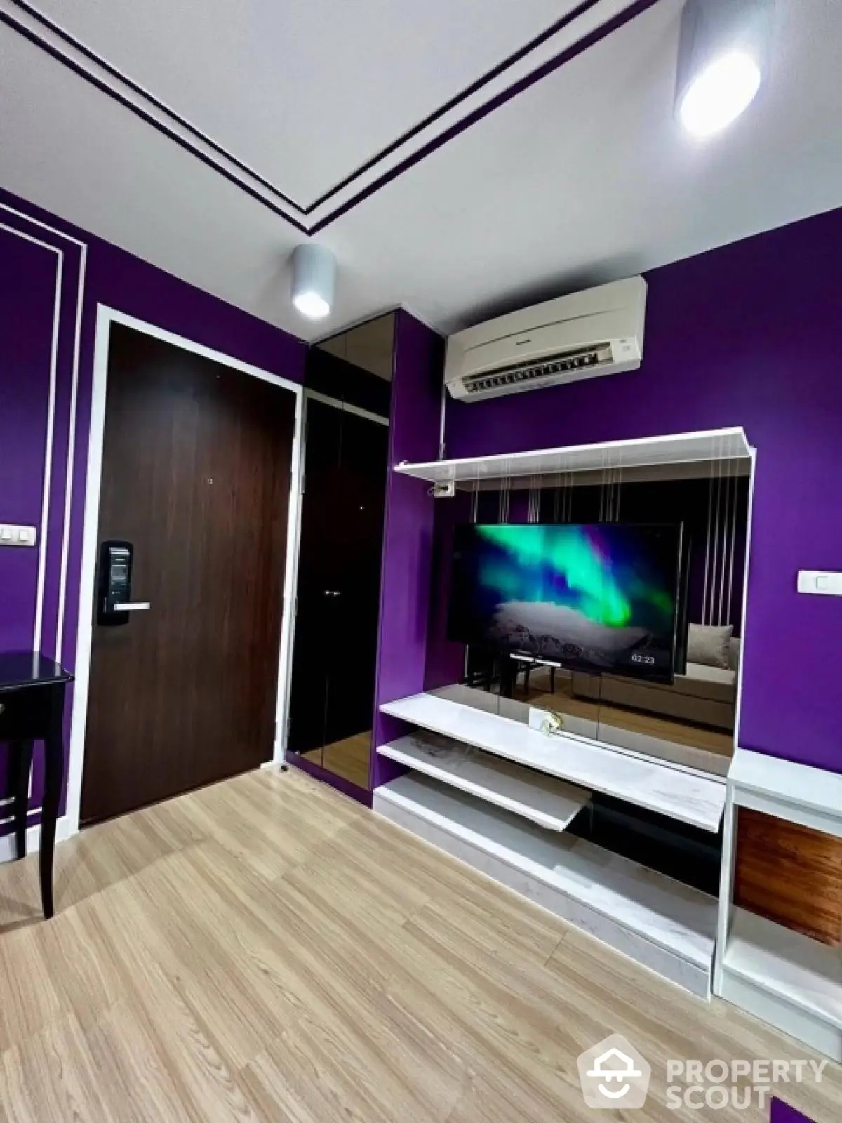 Modern living room with vibrant purple walls and sleek entertainment center