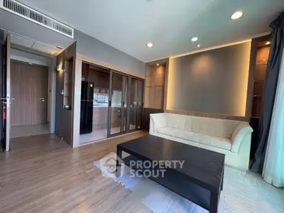 Modern living room with open kitchen, featuring sleek design and cozy ambiance.