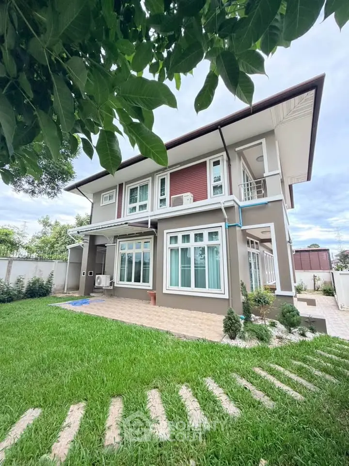Stunning two-story home with lush green lawn and modern exterior design, perfect for family living.