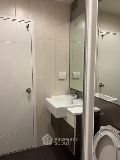 Modern bathroom with sleek sink and large mirror in contemporary design.