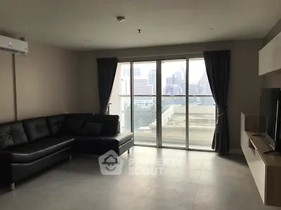 Spacious modern living room with city view and sleek black sofa