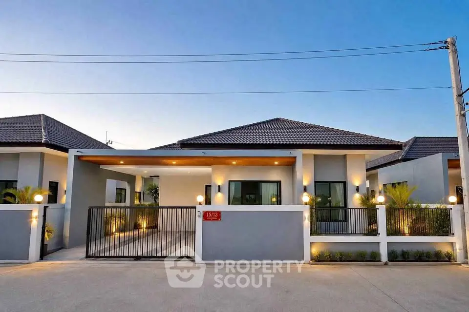 Modern single-story house with sleek design and spacious driveway under a clear blue sky.