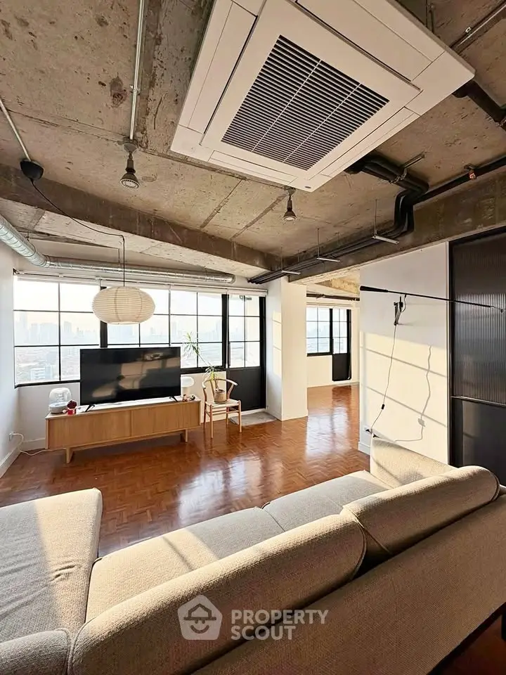Spacious industrial-style living room with large windows and modern decor