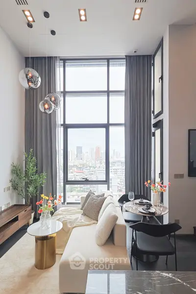 Luxurious living room with high ceilings and city view, featuring modern decor and elegant lighting.