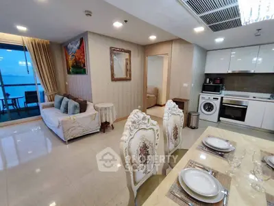 Luxurious open-plan living room and kitchen with elegant dining area and balcony view.