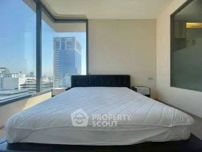 Spacious bedroom with panoramic city views and modern furnishings.