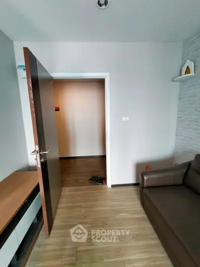 Modern living room with wooden flooring and sleek furniture in a stylish apartment.