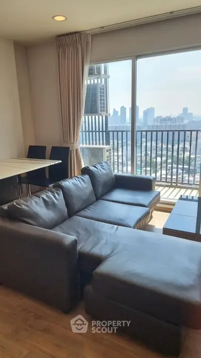 Modern living room with city view and stylish black leather sofa
