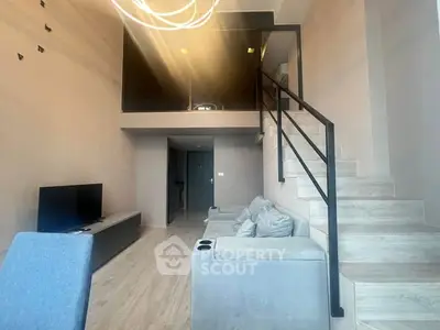 Modern loft-style living room with mezzanine and sleek staircase