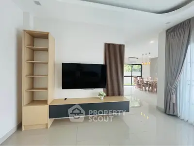 Modern living room with sleek TV unit and dining area view