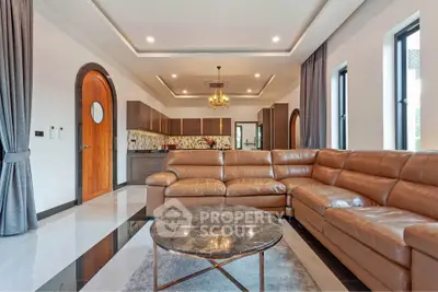 Luxurious living room with leather sectional sofa and modern kitchen in open layout