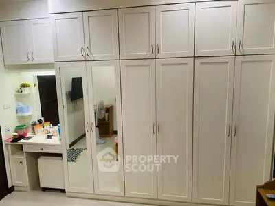 Spacious bedroom with elegant built-in wardrobes and vanity area.