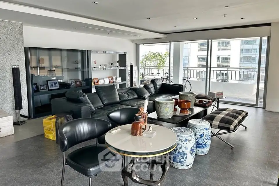 Spacious modern living room with elegant decor and large windows offering city views.