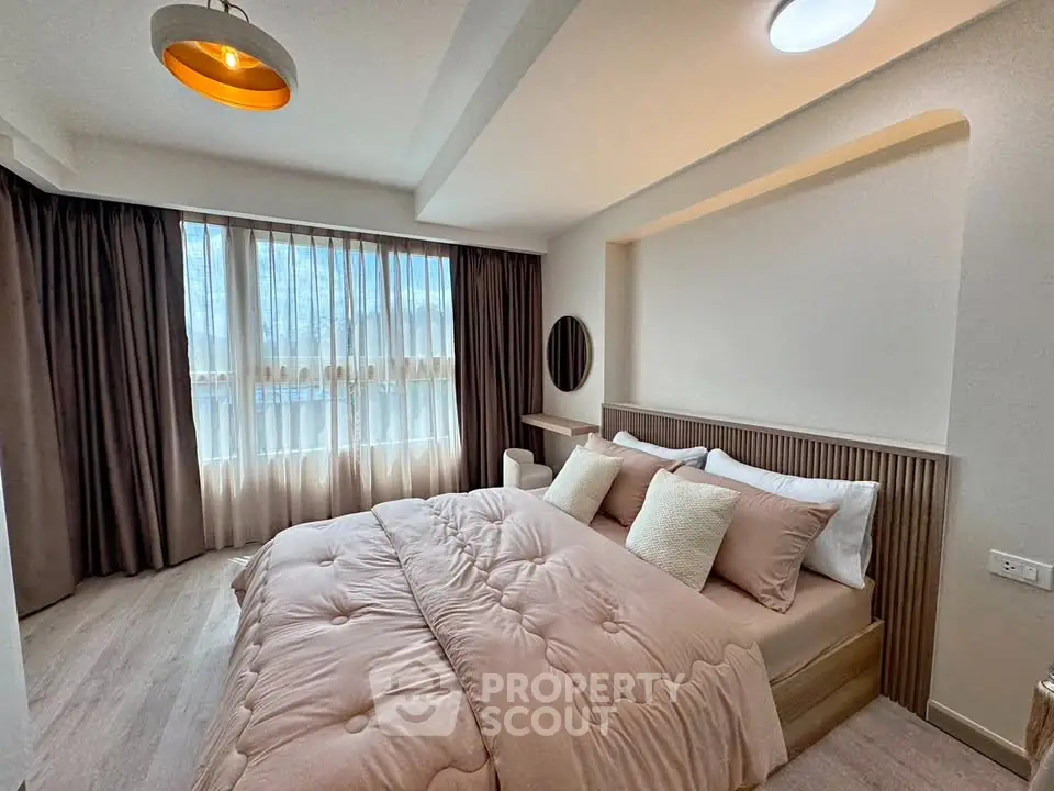 Spacious bedroom with elegant decor and large windows for natural light