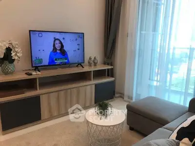 Modern living room with stylish furniture and large TV, perfect for relaxation.
