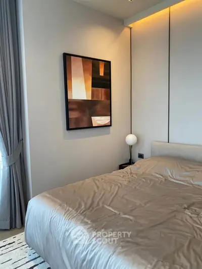 Modern bedroom with stylish decor and cozy ambiance, featuring elegant wall art and soft lighting.