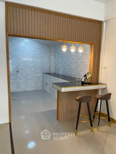 Modern kitchen with stylish breakfast bar and elegant lighting in a contemporary apartment.