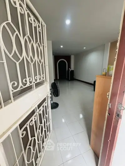 Spacious entryway with modern security gate and sleek tiled flooring