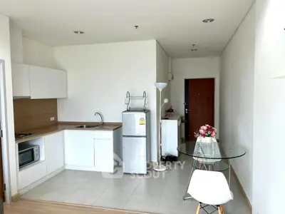 Modern minimalist kitchen with open layout and dining area in bright apartment.