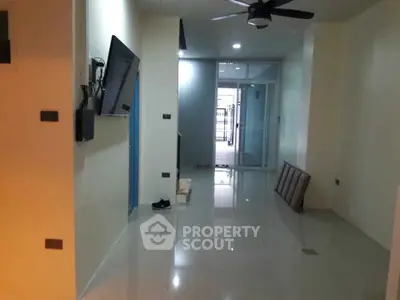 Spacious modern living room with sleek flooring and ceiling fan