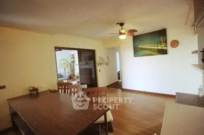 Spacious open-plan living and dining area with modern decor and wooden flooring.