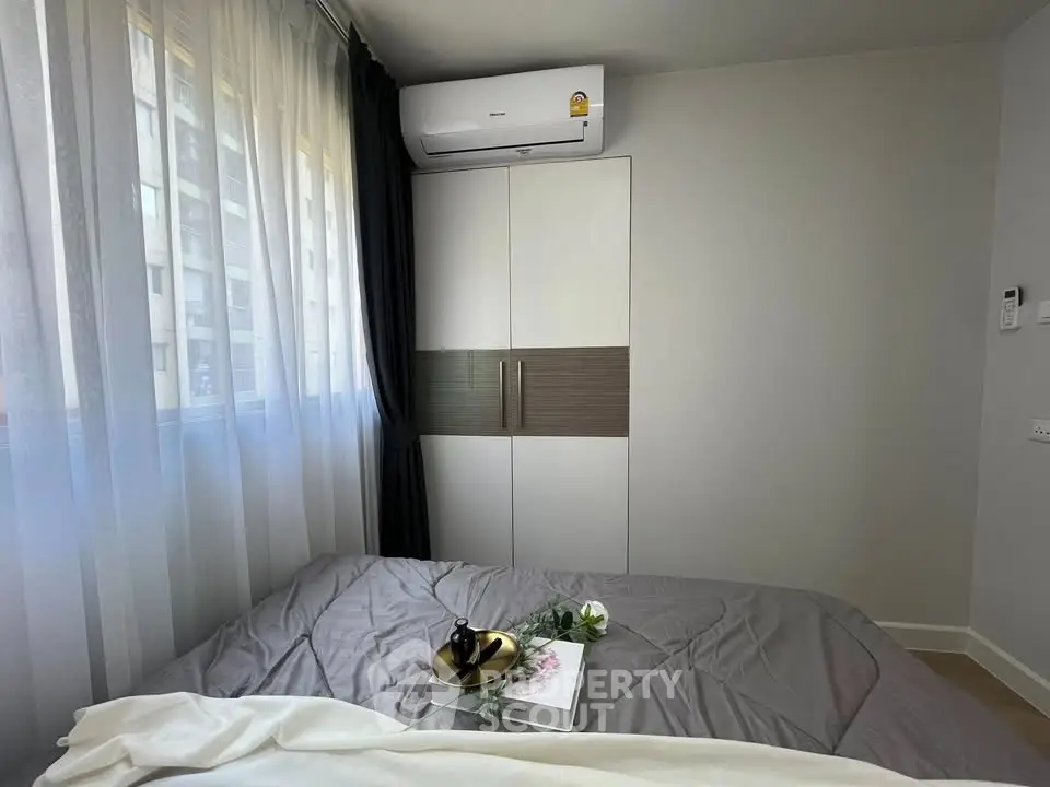 Cozy bedroom with modern air conditioning and stylish wardrobe, perfect for comfortable living.