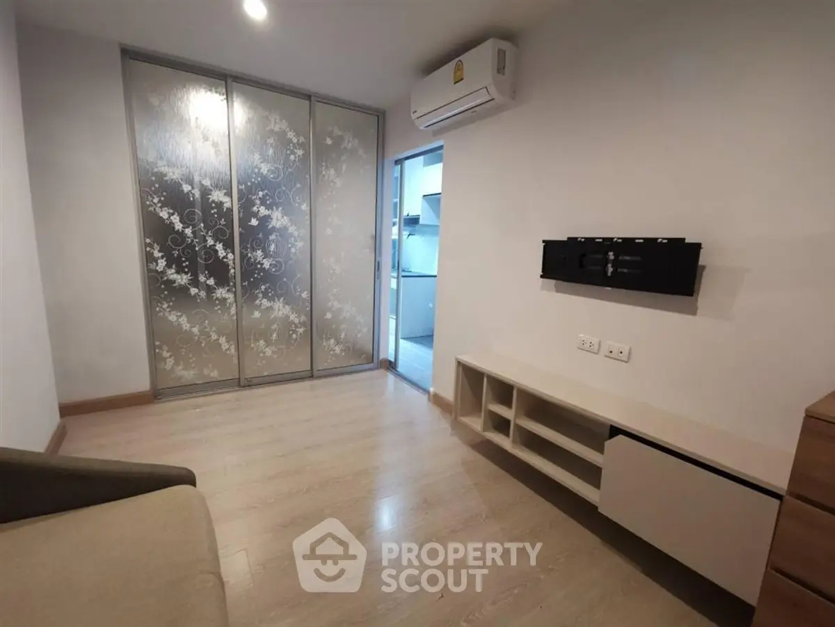 Modern living room with sliding glass doors and air conditioning in a stylish apartment.