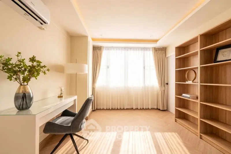 Elegant study room with natural light, modern desk, and stylish shelving in a serene home setting.