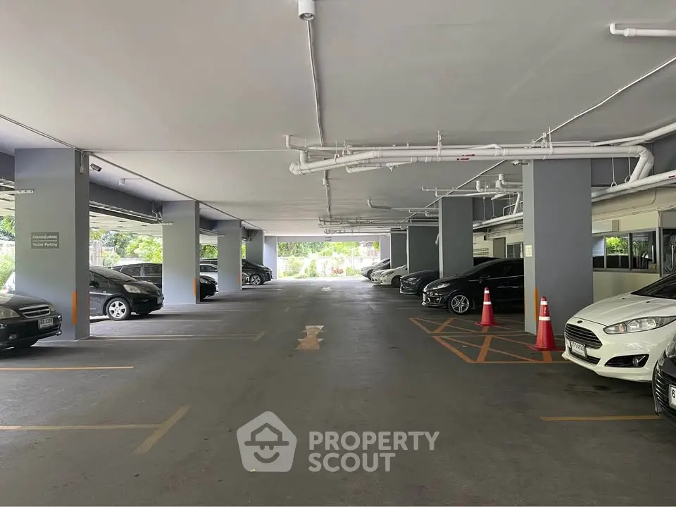 Spacious indoor parking area with multiple cars and clear pathways, ideal for convenient vehicle storage.