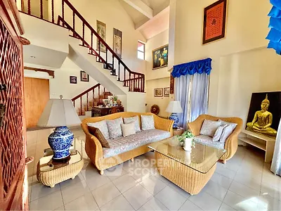 Spacious living room with elegant wicker furniture and artistic decor in a bright, airy home.