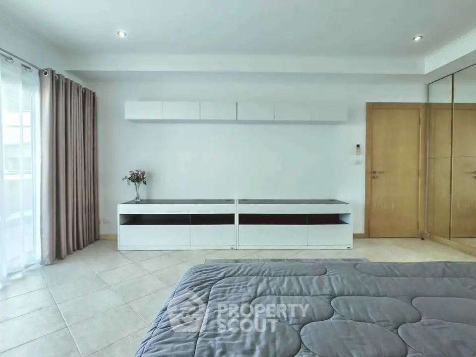 Spacious modern bedroom with sleek storage and natural light