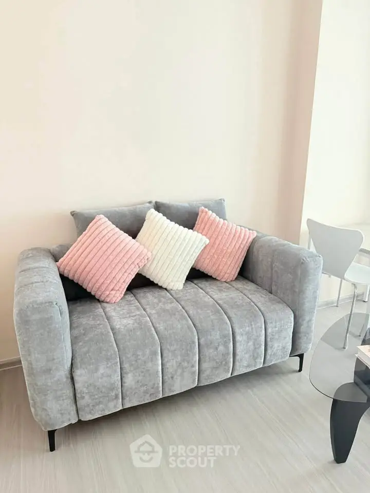 Stylish modern living room with plush gray sofa and chic decor accents.