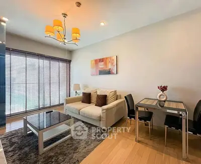 Modern living room with cozy sofa, stylish dining area, and elegant lighting in a bright apartment.