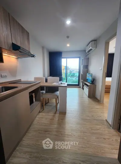 Modern open-plan living room with kitchen and balcony view