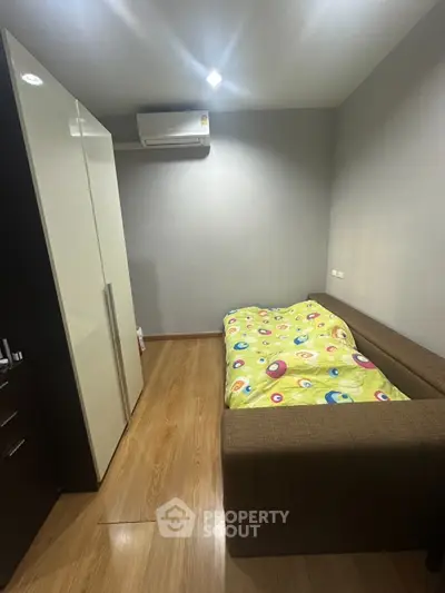 Cozy bedroom with modern wardrobe and air conditioning, perfect for comfortable living.