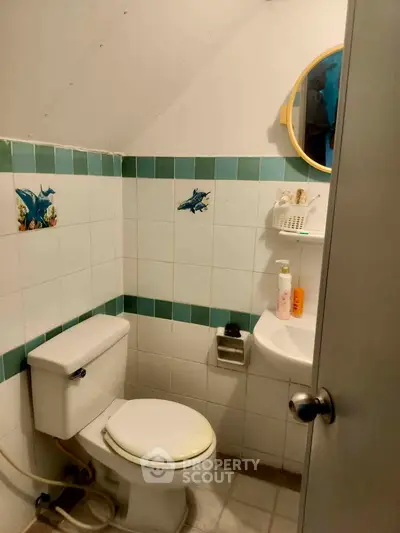 Cozy bathroom with unique tile accents and compact design, perfect for efficient space utilization.