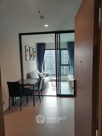 Modern apartment interior with open living room and dining area, featuring large windows and stylish decor.