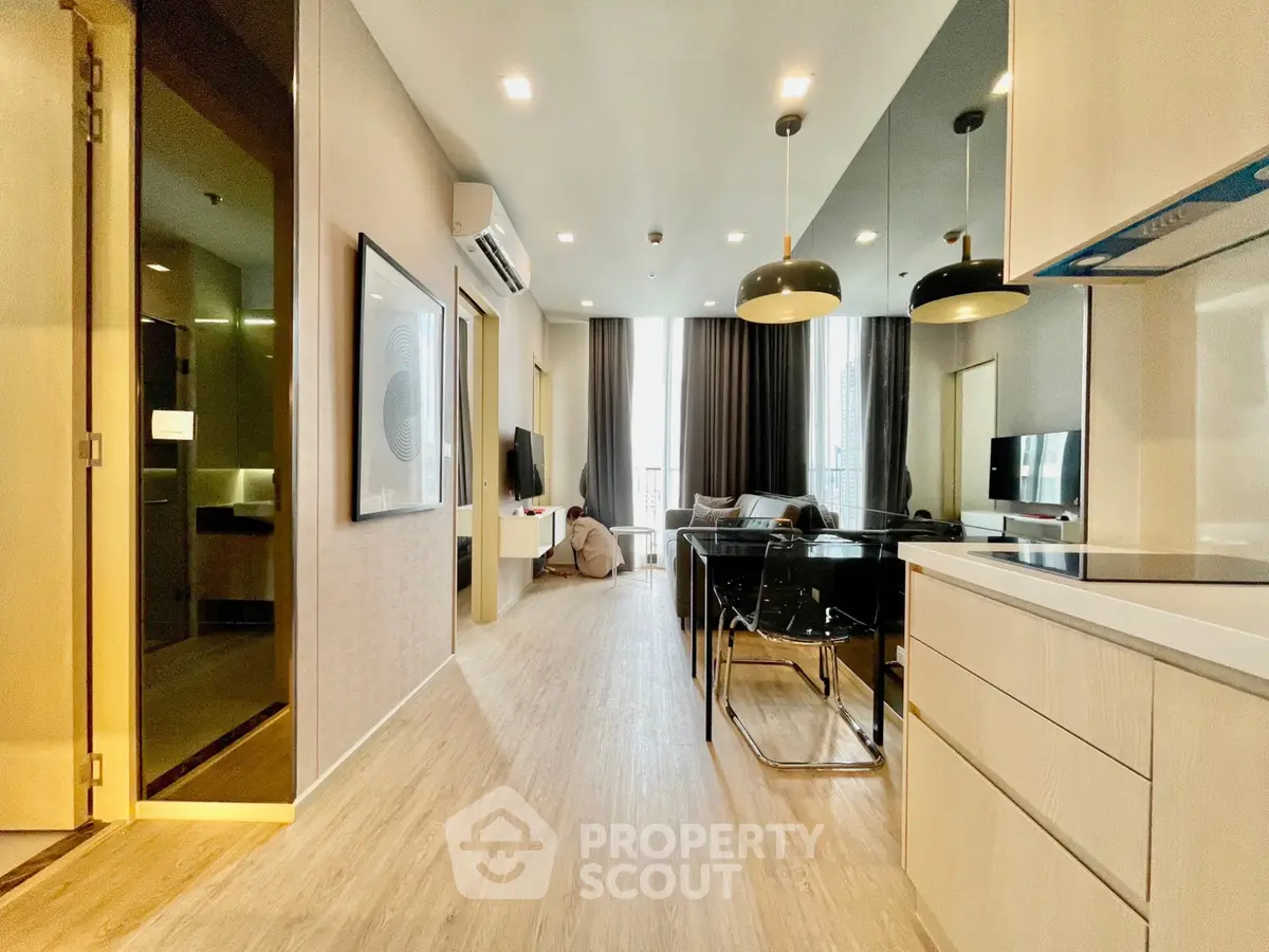 Modern open-layout living room with stylish kitchen and dining area in a contemporary apartment.
