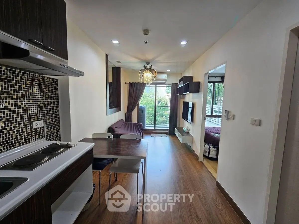 Modern open-layout living room with kitchen and balcony view in stylish apartment