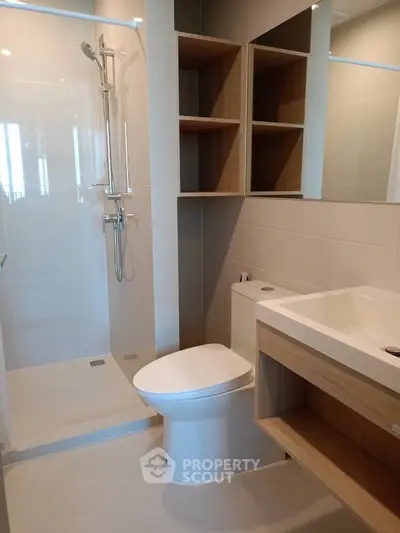 Modern bathroom with sleek shower and wooden storage shelves.