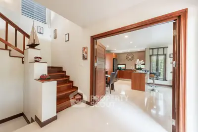 Spacious modern living area with wooden staircase and open layout, perfect for family gatherings.