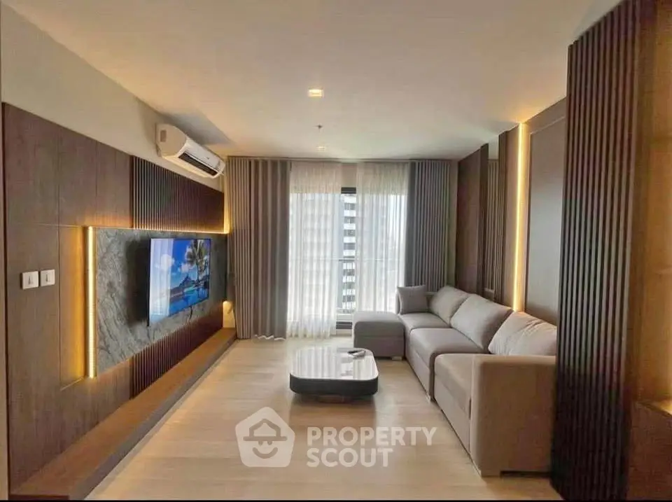 Modern living room with sleek design, large TV, and comfortable sofa in a stylish apartment.