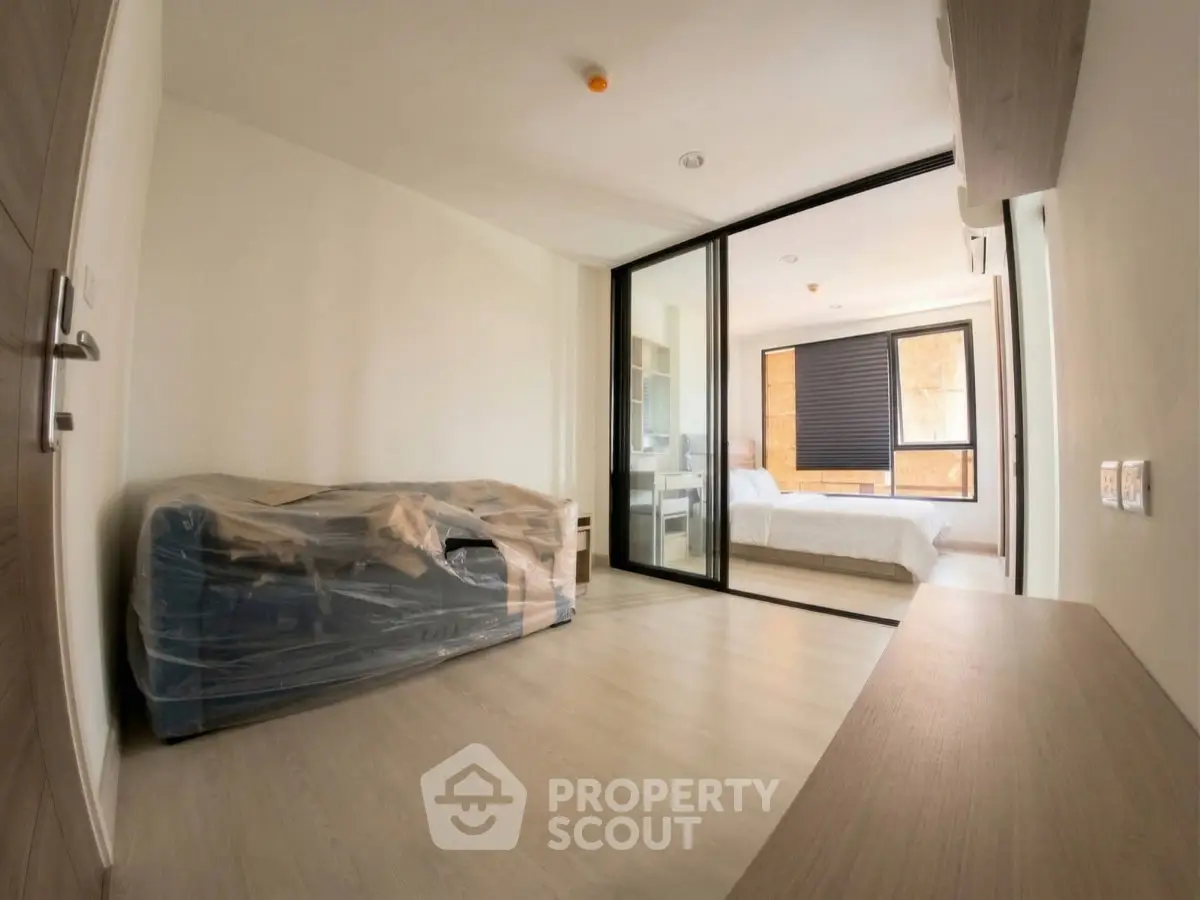 Modern apartment with spacious living area and bedroom, featuring sleek design and natural light.